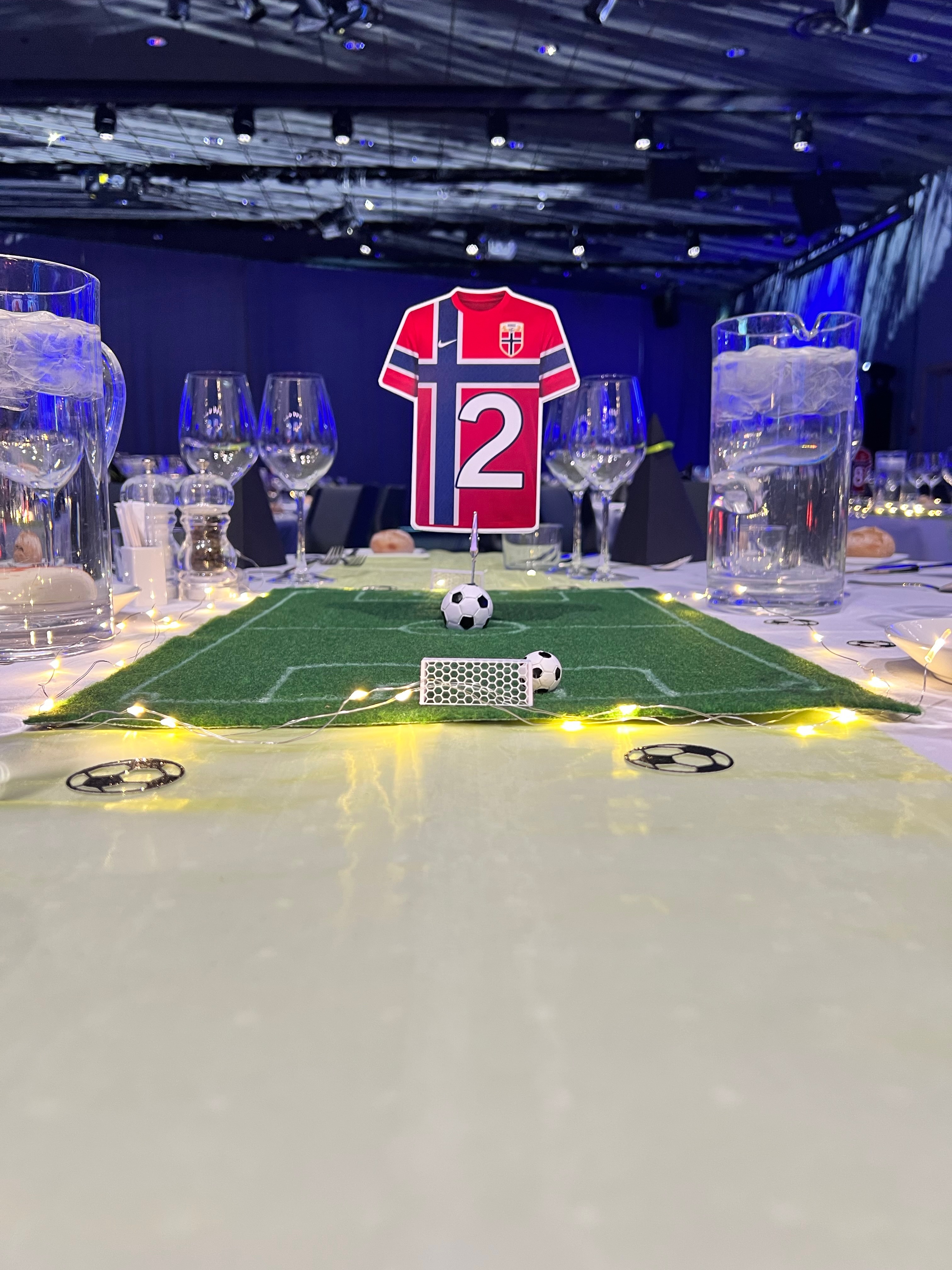 Detaljbilde av borddekor med liten fotballbane og 3D-printet mål